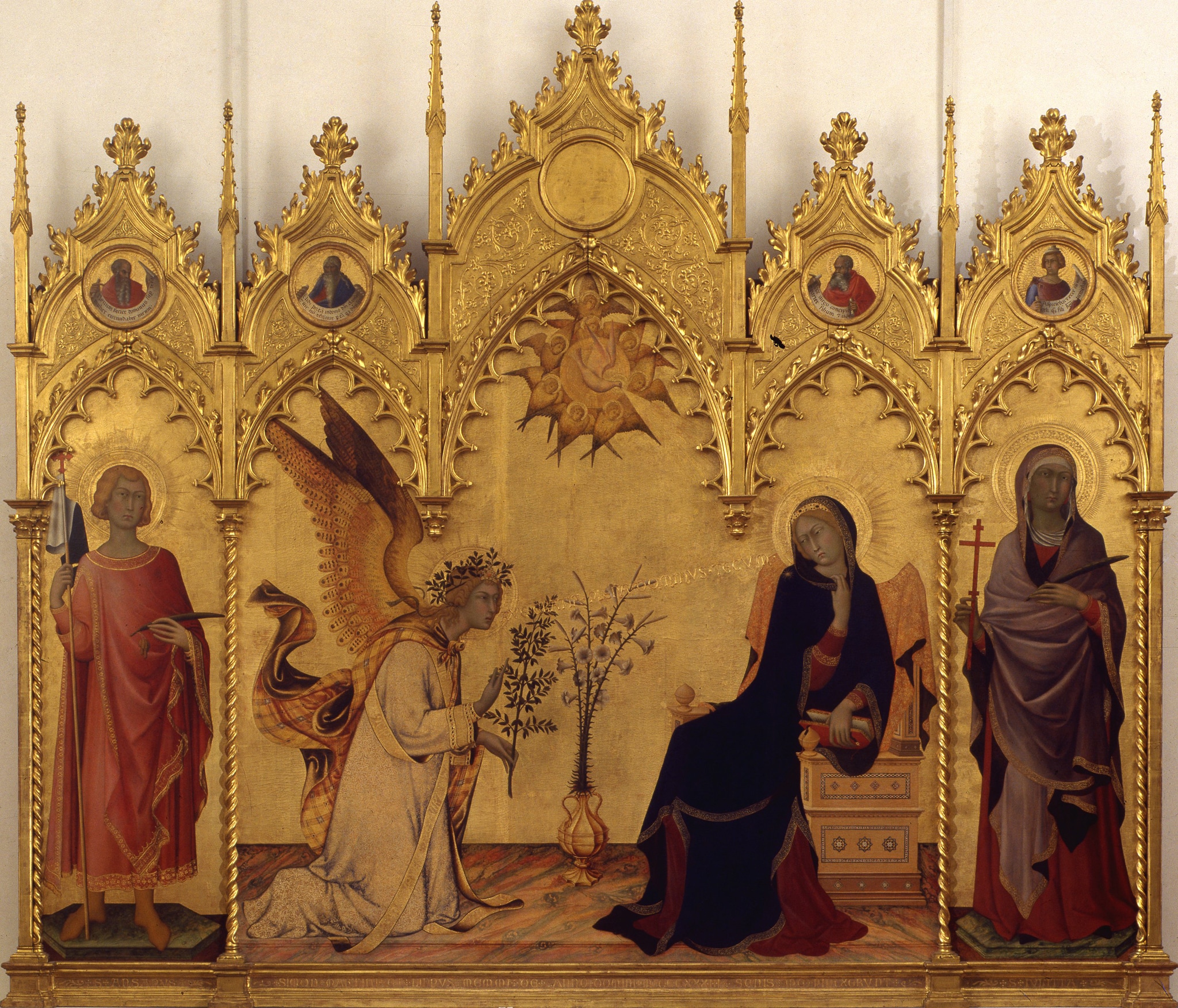 Simone Martini, Annunciazione e i santi Ansano e Massima, 1333, scomparto di trittico, tempera su tavola, fondo oro, 184x210cm. La tavola firmata e datata, fu eseguita per l’altare di Sant’Ansano del transetto del Duomo di Siena, dove rimase fino al 1799, quando il Granduca Pietro Leopoldo la portò agli Uffizi. La straordinaria raffinatezza lineare che non ha modelli coevi in Italia, aprì la strada all'artista fra i pittori italiani alla corte papale di Avignone.