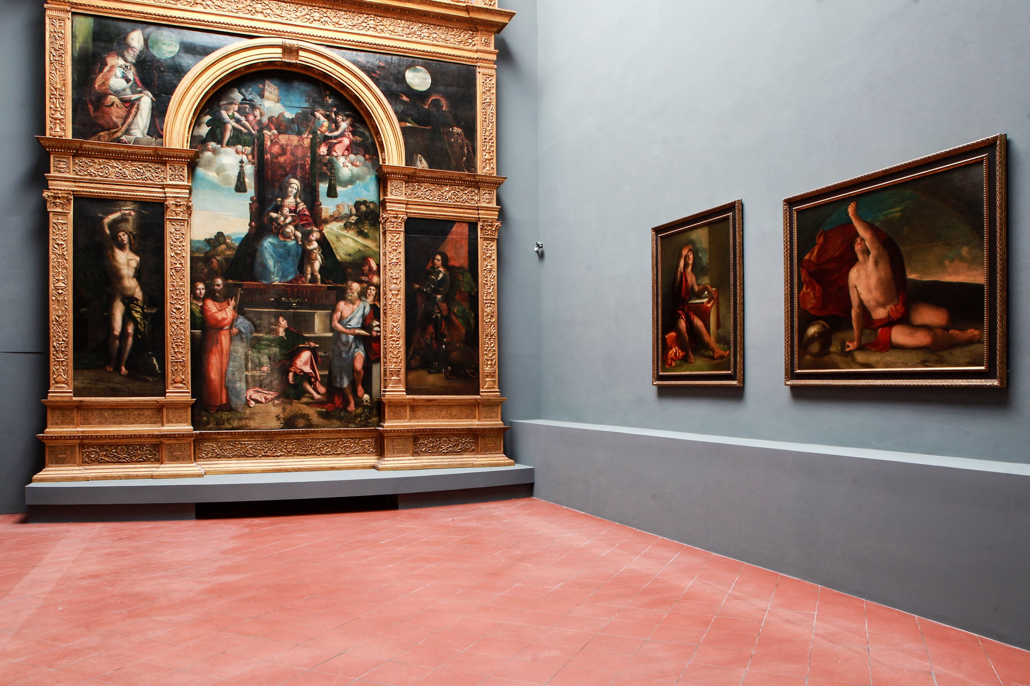 Sala 19. A chiudere il percorso della Pinacoteca, una delle opere più celebri del museo, l’imponente polittico Costabili, realizzato da Garofalo e Dosso Dossi fra il 1513 e il '22 per l’abside della chiesa di Sant’Andrea a Ferrara. A destra, le due opere di maggior pregio della Fondazione Estense: i Sapienti dipinti da Dosso attorno al 1522. 