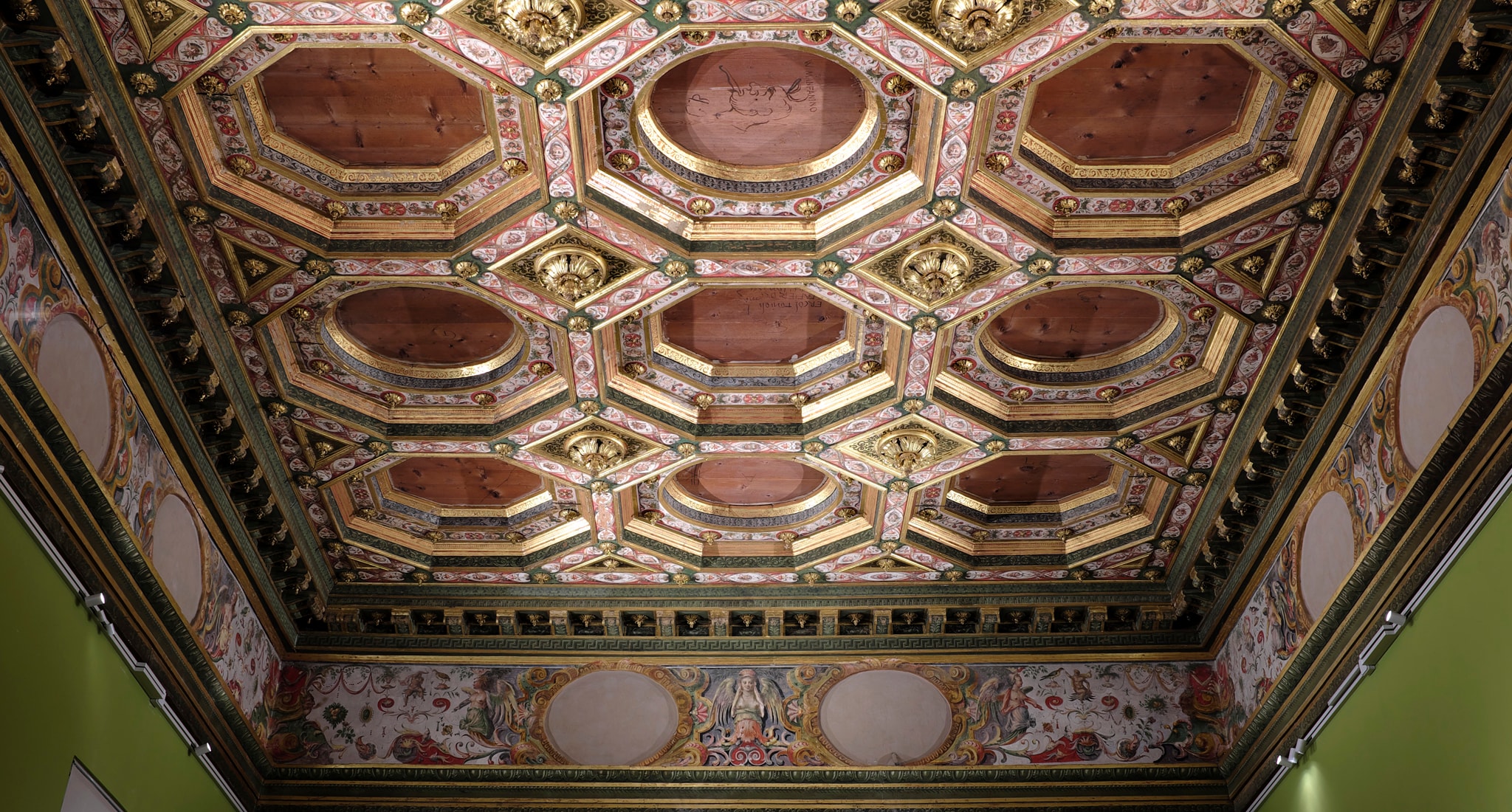 Sala 16. Soffitto della sala del Parto, decorata dal ferrarese Giulio Belloni (1592-93). I cassettoni dorati e decorati e gli ovali del fregio a grottesche lungo le pareti, ospitavano in origine dipinti di Gaspare Venturini, Bastianino e Scarsellino, oggi in parte esposti nella Galleria Estense di Modena, assieme alle tele di Agostino, Ludovico e Annibale Carracci che decoravano la precedente sala del Poggiolo.