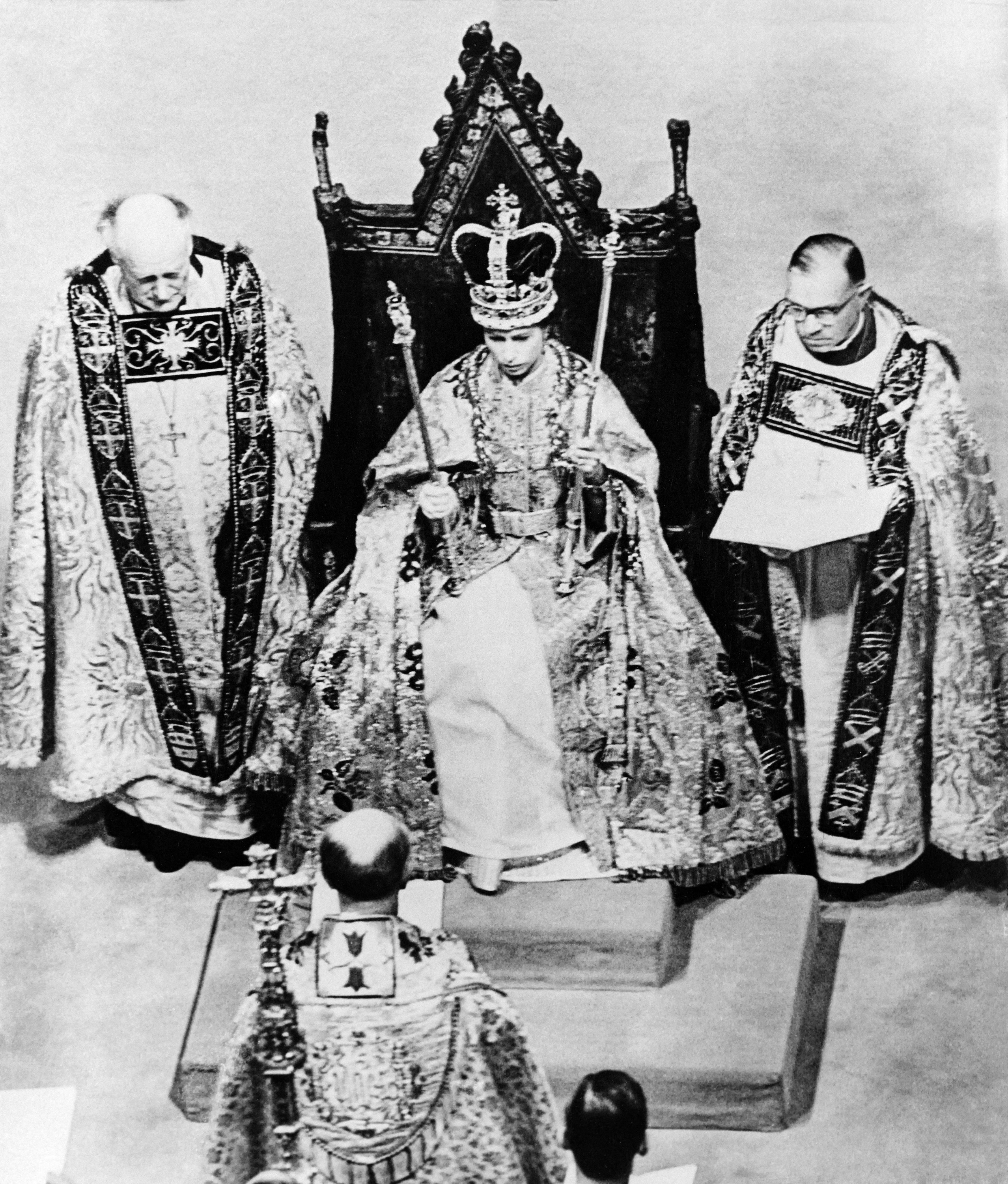 La regina Elisabetta II, seduta sulla sedia di Sant'Edoardo, tiene gli Sceptres, il 2 giugno 1953 presso l'Abbazia di Westminster, durante la sua incoronazione, a Londra, per la prima volta trasmessa anche in televisione