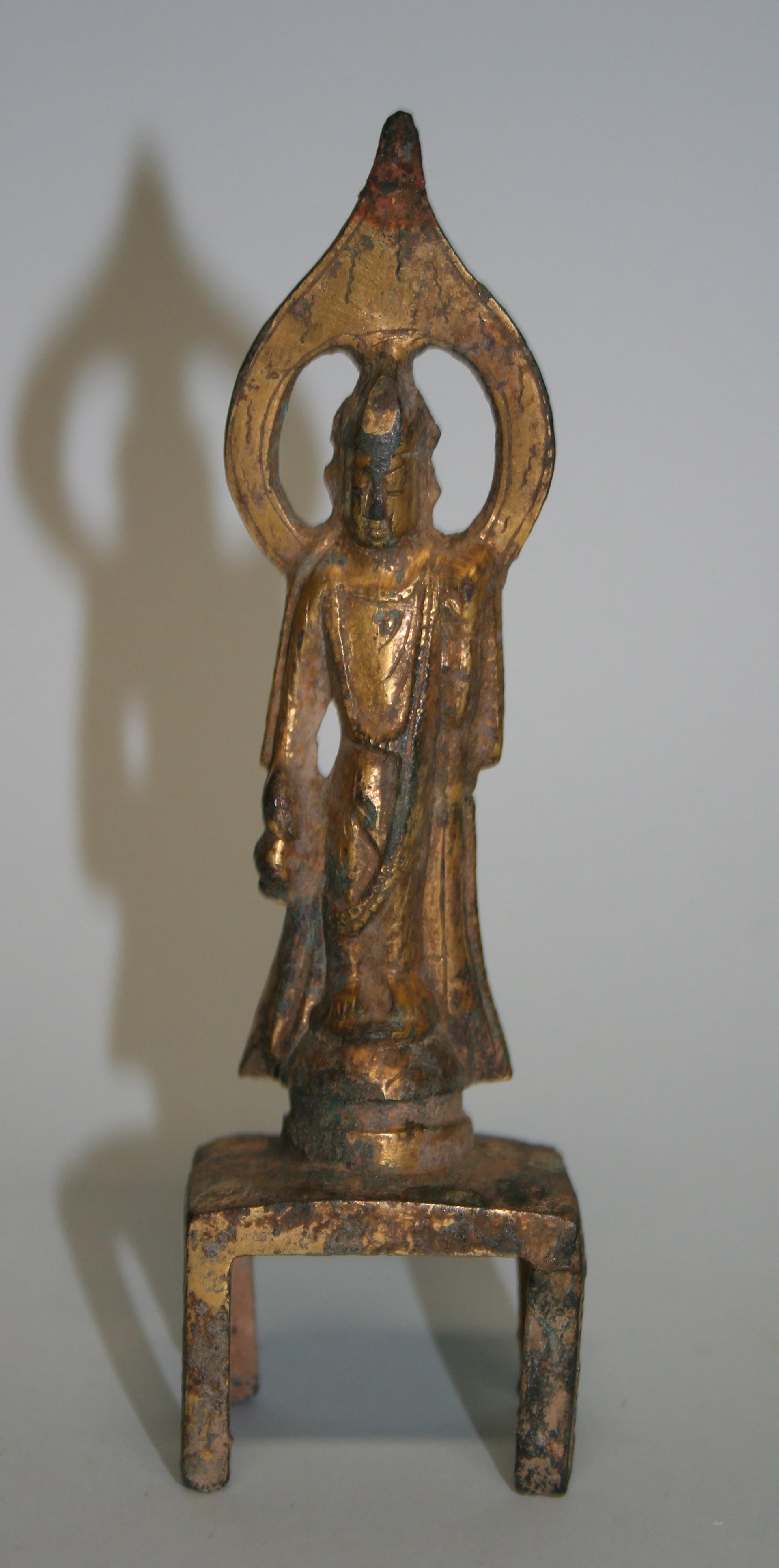 Statuina di Bodhisattva in piedi raffigurante Bodhisattva con aureola traforata e alta base sottile. Provenienza: Cina. Cronologia generica: VII secolo d.C. (?) Dinastie: Sui - Tang Materia e Tecnica: bronzo dorato. Altezza: 13,4 cm. Larghezza: 3,9 cm. 