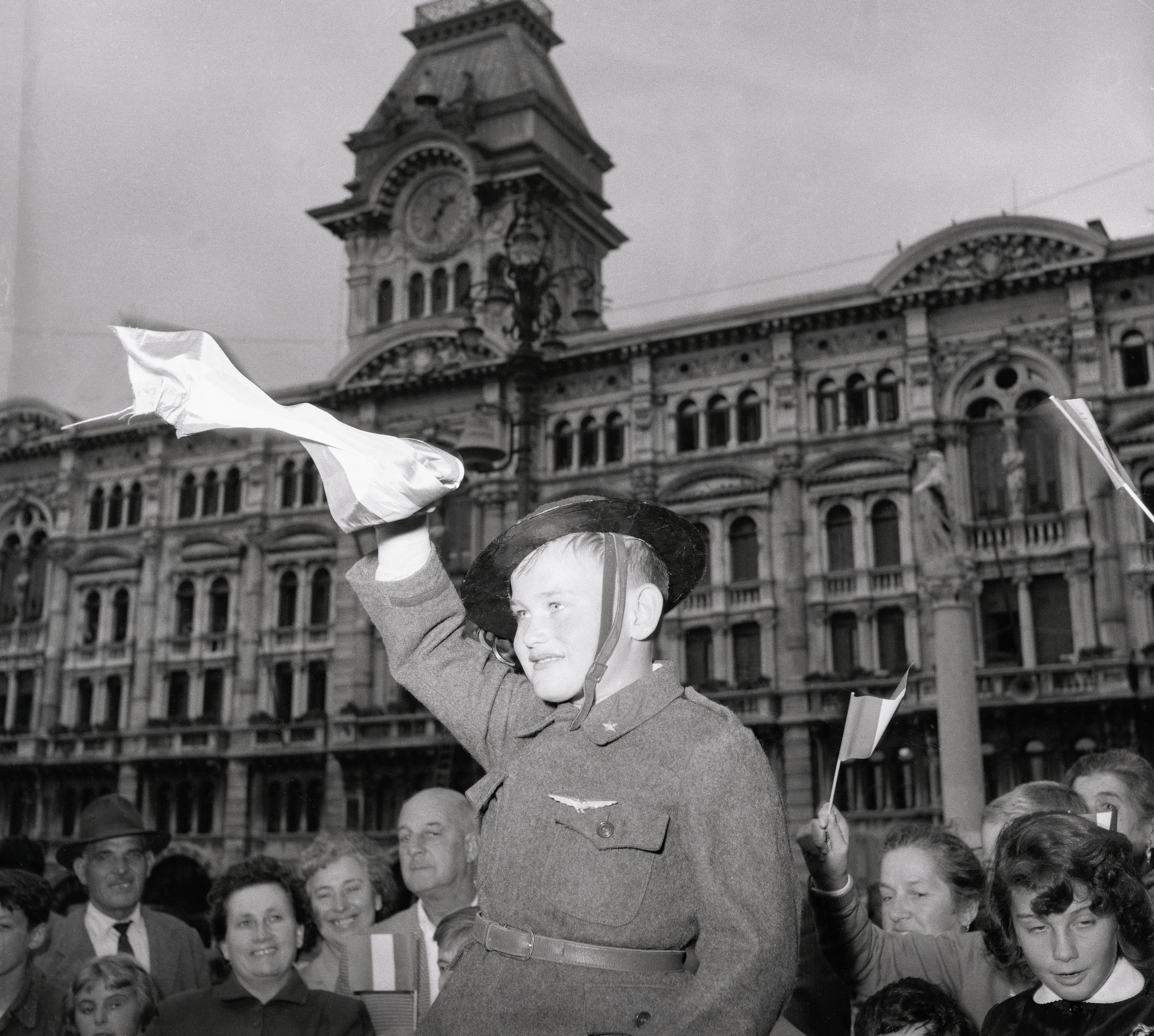 Un giovane residente a Trieste sventola la bandiera tricolore italiana celebrando il ritorno della città portuale all'Italia. Indossa un cappello da bersagliere, i primi ad entrare a Trieste il 21 ottobre