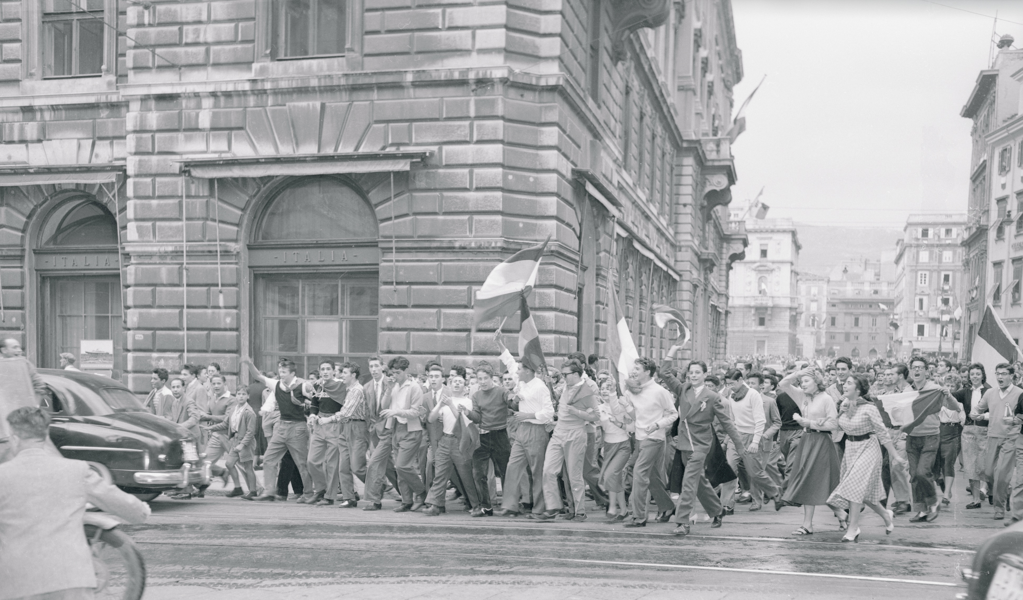 Studenti esultanti, alcuni con striscioni, marciano per le strade di Trieste dopo aver appreso la notizia dell'accordo tra Italia e Jugoslavia sulla spartizione del territorio libero di Trieste